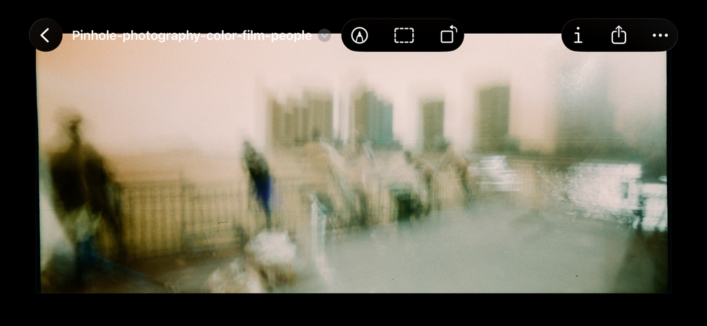 Before Bleach Bypass Lut is applied  - A blurry, artistic photograph of a waterfront scene with indistinct figures, a railing, and buildings, presented inside a screenshot-style frame with browser or app interface icons visible at the top.
