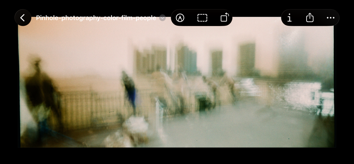 Before Bleach Bypass Lut is applied  - A blurry, artistic photograph of a waterfront scene with indistinct figures, a railing, and buildings, presented inside a screenshot-style frame with browser or app interface icons visible at the top.